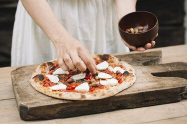 Frau, die Oliven auf selbstgemachte Pizza legt, Mittelteil - CUF10529