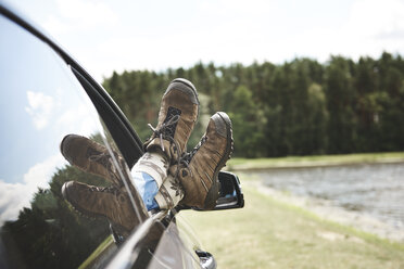 Woman relaxing in car, feet through open window, focus on feet - CUF10542