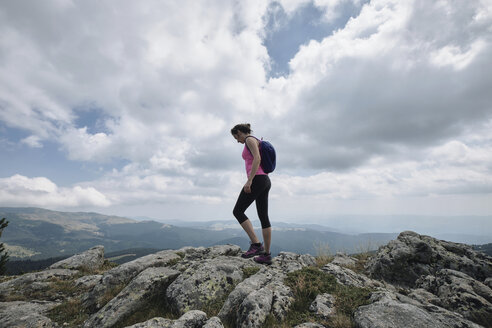 Bulgaria, Rila Mountain, female hiker standing on cliff edge - BZF00392