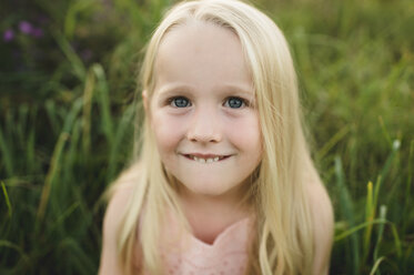 Portrait of blonde haired girl looking at camera smiling - CUF10573