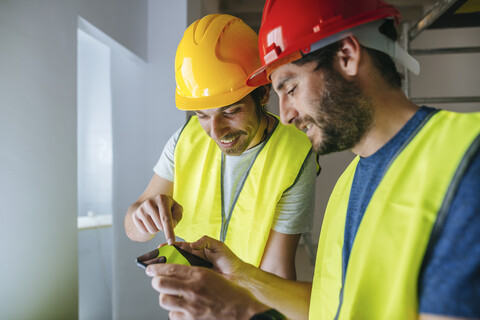 Arbeiter, die auf das Mobiltelefon schauen, lizenzfreies Stockfoto