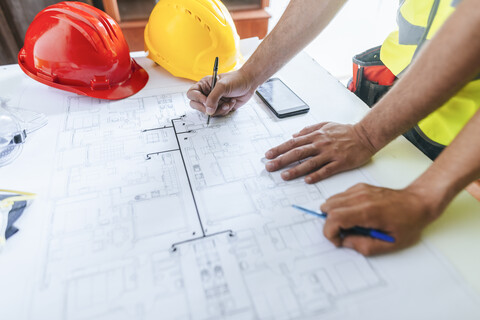 Close-up of workers hands working on construction plan stock photo