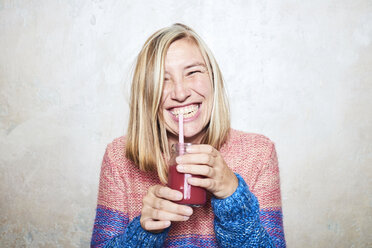 Portrait of woman drinking smoothie, smiling - CUF10673