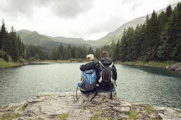 Rückansicht eines wandernden Paares, sitzend am See, Tirol, Steiermark, Österreich, Europa - CUF10696