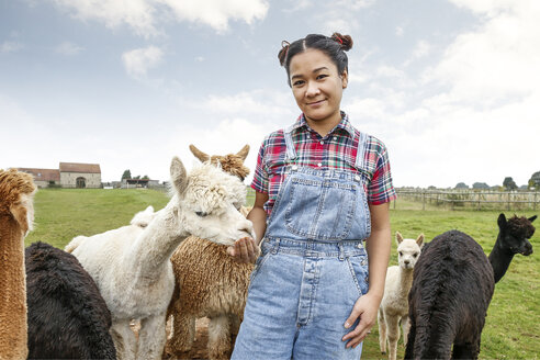 Porträt einer Frau mit Alpakas auf einem Bauernhof - CUF10700