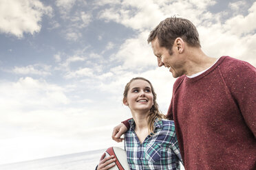 Father and daughter walking along beach together - CUF10704