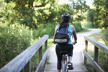 Cyclist riding across bridge - CUF10709