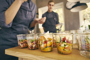 Chef filling plastic containers with portions of food - CUF10764