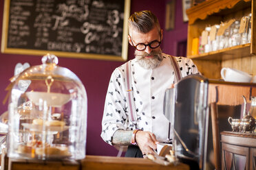 Skurriler älterer Mann mit Kaffeemaschine in Teestube - CUF10801