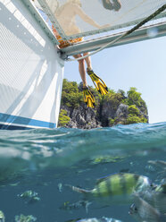 Legs of woman dangling from yacht, Koh Pak Ka, Krabi, Thailand, Asia - CUF10848