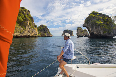 Mann entspannt sich auf einer Yacht und blickt weg auf Koh Li Ma, Thailand, Asien - CUF10851
