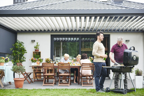 Zwei Männer beim Grillen auf der Terrasse beim Familienessen - CUF10852