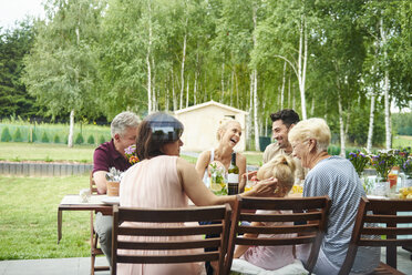 Three generation family having lunch on patio table - CUF10860