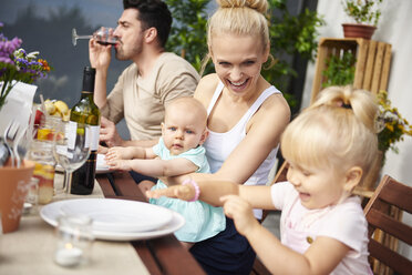 Ehepaar mit Baby und Kleinkind Töchter bei Familie Mittagessen auf Terrasse Tisch - CUF10861