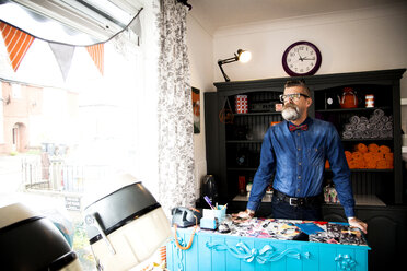 Man at reception desk of quirky hair salon - CUF10883