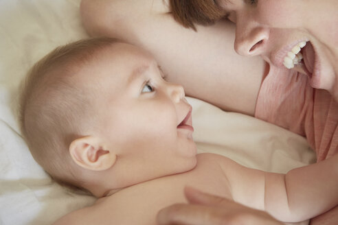 Mittlere erwachsene Frau auf dem Bett mit Blick auf ihren kleinen Sohn - CUF10891