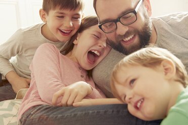 Vater und drei Kinder lachen zusammen - CUF10900