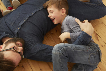 Overhead view of boy and father laughing on floor - CUF10914