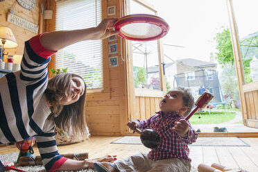 Childminder and baby boy playing with tambourine - CUF10947