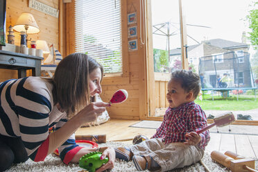 Childminder shaking maraca at baby boy - CUF10949