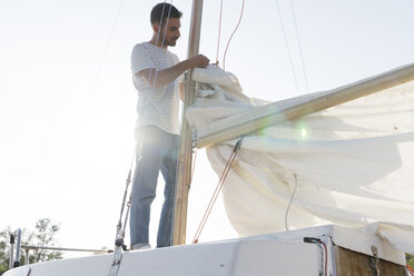 Mann auf Segelboot, Vorbereitung zum Hissen der Segel - CUF10955