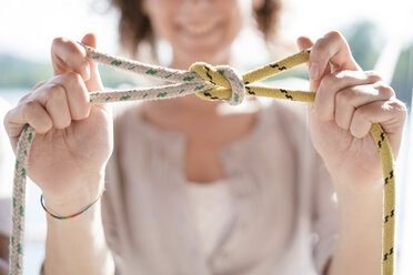 Frau hält Seil mit nautischem Knoten - CUF10960
