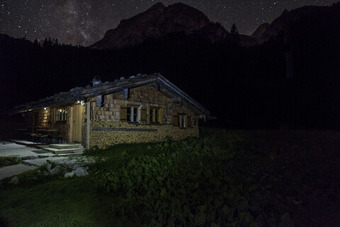 Deutschland, Bayern, Berchtesgadener Alpen, Wasseralm, Holzhütte, Milchstraße bei Nacht, lizenzfreies Stockfoto