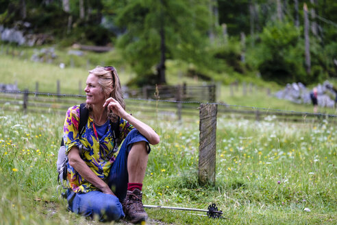 Wanderin sitzt auf einer Wiese - HAMF00312