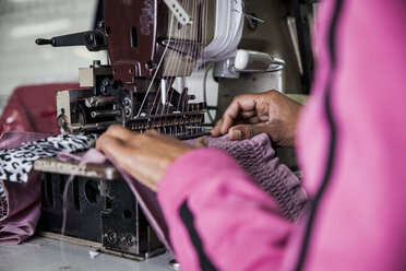 Näherin bei der Arbeit an einer industriellen Smok-Nähmaschine in einer Fabrik, Kapstadt, Südafrika - CUF10980