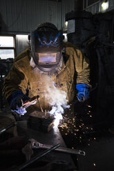 Schmied mit Schweißmaske beim Schweißen von Metall in der Werkstatt - CUF11074
