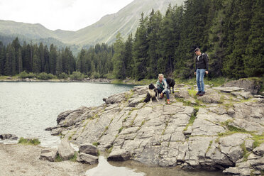 Couple with dogs hiking by lake, Tirol, Steiermark, Austria, Europe - CUF11083
