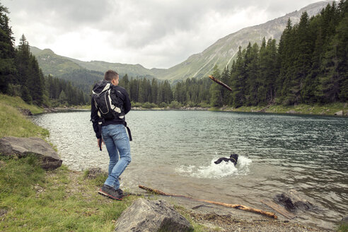 Man with dog hiking by lake, Tirol, Steiermark, Austria, Europe - CUF11084