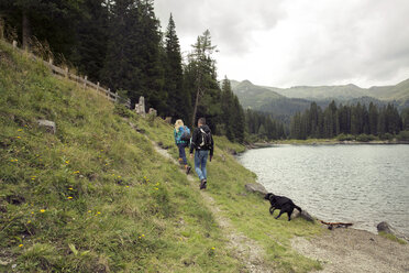 Ehepaar mit Hund beim Wandern am See, Tirol, Steiermark, Österreich, Europa - CUF11085