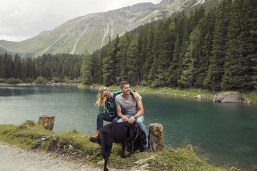 Couple with dog, hiking, sitting by lake, Tirol, Steiermark, Austria, Europe - CUF11086