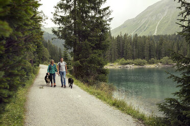 Ehepaar mit Hunden beim Wandern am See, Tirol, Steiermark, Österreich, Europa - CUF11087