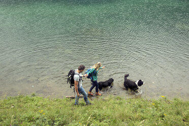 Ehepaar mit Hunden beim Wandern am See, Tirol, Steiermark, Österreich, Europa - CUF11088