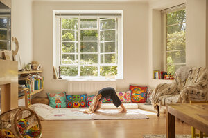Junges Mädchen zu Hause, gebückt in Yoga-Position - CUF11198