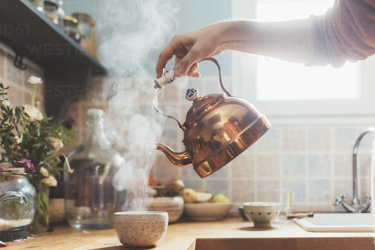 https://us.images.westend61.de/0000947138pw/arm-of-man-pouring-boiling-water-into-bowl-in-kitchen-CUF11266.jpg