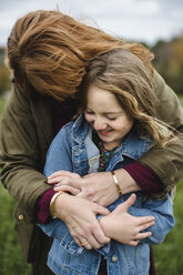 Mother and daughter hugging in meadow - CUF11271