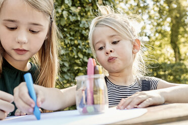 Sisters colouring out in garden - CUF11319