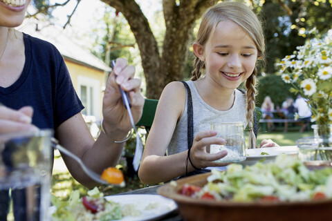 Mutter und Tochter beim Mittagessen im Garten, lizenzfreies Stockfoto