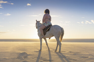 Frau reitet Pferd am Strand, Rückansicht, Jericoacoara, Ceara, Brasilien, Südamerika - CUF11349