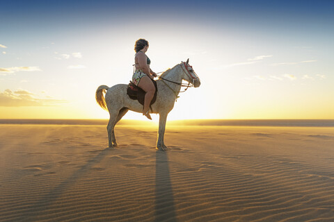 Woman riding horse on beach, side view, Jericoacoara, Ceara, Brazil, South America stock photo