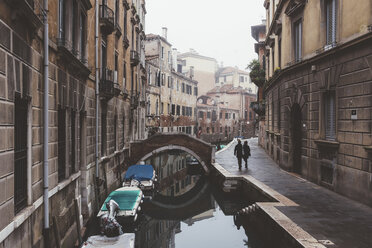 Rear view of couple strolling along canal waterfront, Venice, Italy - CUF11364