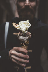 Hand of man holding gelato in dark alley, Venice, Italy - CUF11369