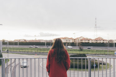 Young woman, standing on footbridge, looking at view, rear view - CUF11411