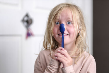 Porträt eines lächelnden kleinen Mädchens, das mit einem blauen Löffel spielt - HAMF00316