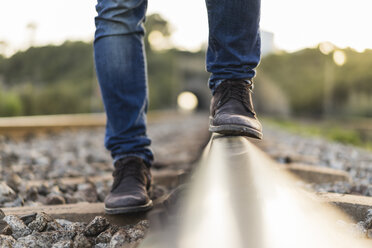 Young man standing on railroad track - AFVF00483