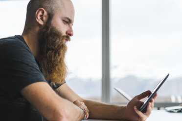 Insel, ernster Hipster, der in einem Café auf sein Handy schaut - AFVF00485