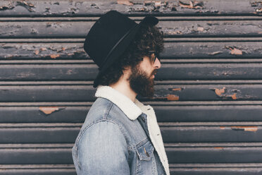 Profile of young man, standing in front of shutter - CUF11415